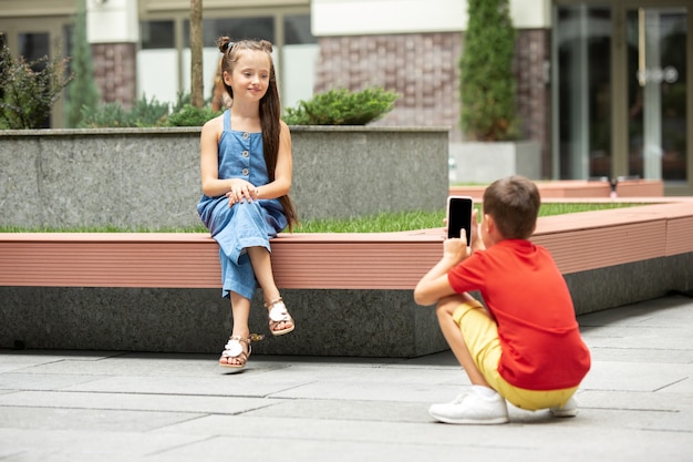 Premium Photo | Two smiling kids, boy and girl taking photo together in ...