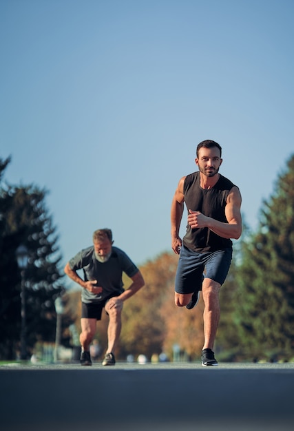 Premium Photo The Two Sportsmen Running Marathon In The Beautiful Park