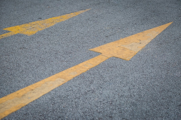 2つの黄色の矢印古いと新しい方向にアスファルト道路の背景 プレミアム写真