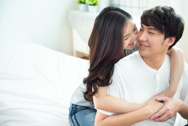 Premium Photo | Two young asian couple girl piggyback man from back on  bed,romantic asia people in love hugging while sitting in bed,valentine day  concept with copy space.