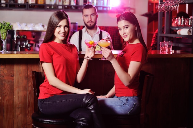 Premium Photo Two Young Cute Girls Drink Cocktails In A Nightclub Or Bar