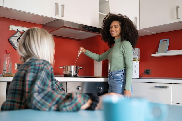 Premium Photo | Two young multiracial students girls cooking in the ...