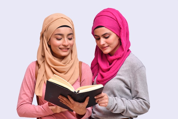 Premium Photo | Two young muslim girl wearing hijab and reading book ...