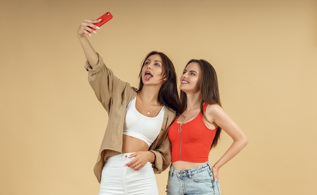 Premium Photo Two Young Women Taking Selfie On Smartphone On Isolated