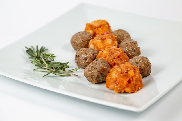 Types of meatballs on a white plate on white Free Photo