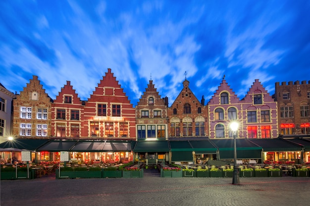 Typical flemish colored houses on the grote markt or market square in the center of bruges during evening blue hour, belgium Premium Photo
