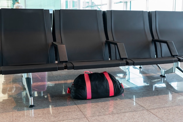 Premium Photo | Unattended luggage bag left under chair in the airport ...