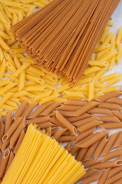 Free Photo | Uncooked macaroni with fresh raw pasta on white space.