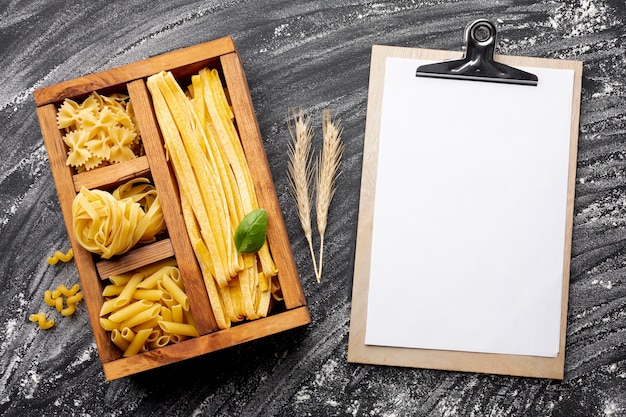 Download Uncooked pasta in wooden box with clipboard mock-up Photo | Free Download