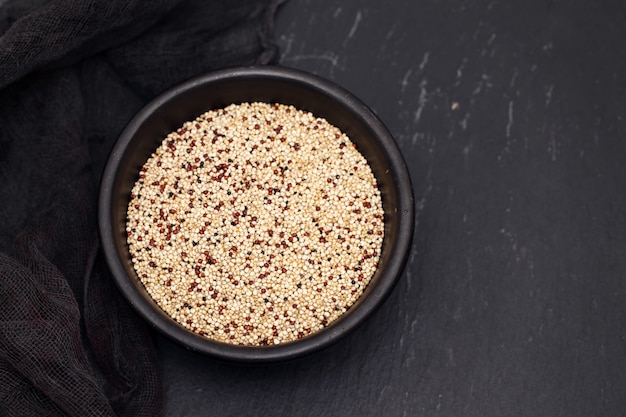 Premium Photo | Uncooked quinoa in black bowl