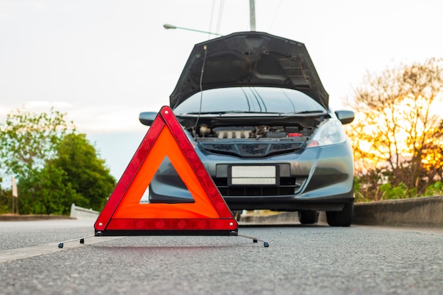 Unexpected situation, emergency stop sign and broken city car on road. Premium Photo