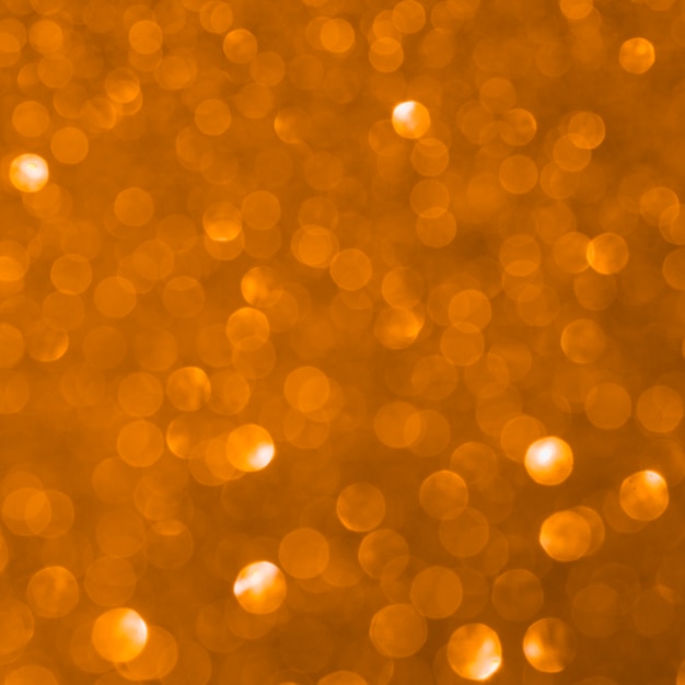 やり場のないオレンジ色のキラキラ背景 無料の写真