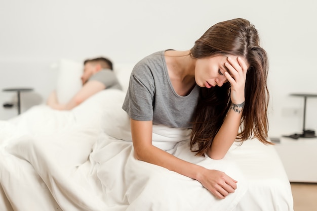 Premium Photo | Unhappy woman in bed with a sleeping man. relationship ...