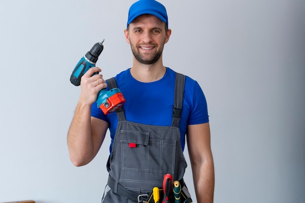 Premium Photo | Uniformed maintenance worker holds a screwdriver and ...