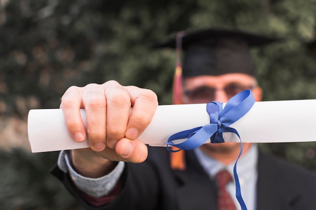 Unrecognizable man showing diploma Free Photo