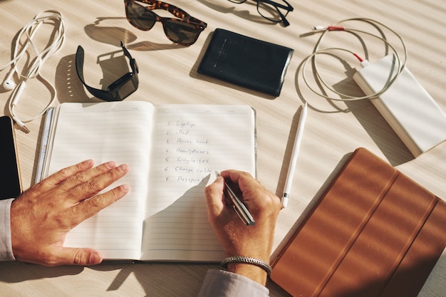 10 Mental Health Tips For Men When You're Feeling Down 7 Free Photo | Unrecognizable man writing plan in journal and gadgets lying around on desk