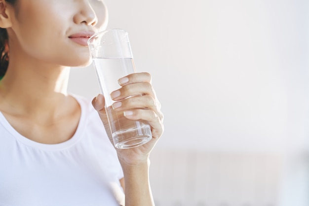 Unrecognizable woman carrying glass of water to mouth Free Photo