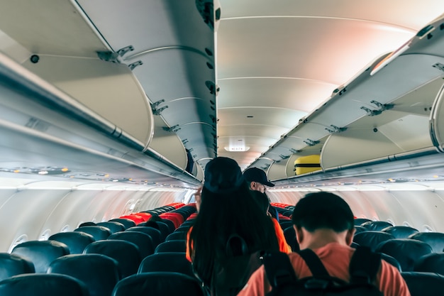 Unspecified passengers were walking out of the plane following the exit sign Premium Photo