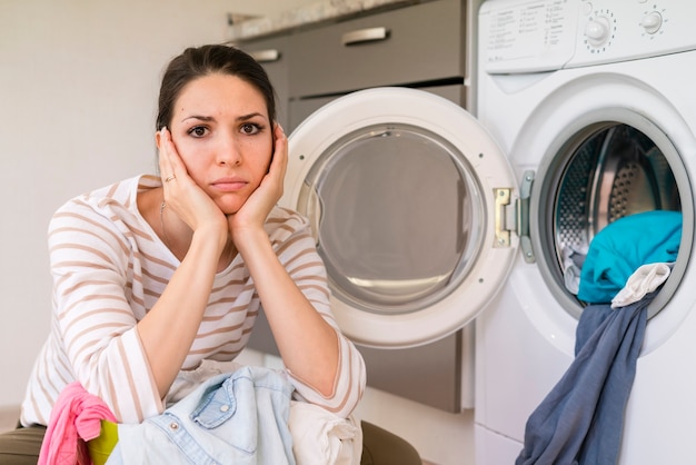 Upset woman doing laundry portrait Free Photo
