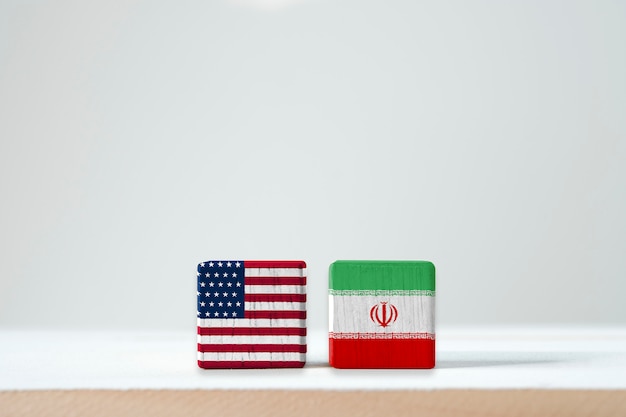 Usa flag and iran flag print screen on wooden cubic.it is symbol of united state of america and iran