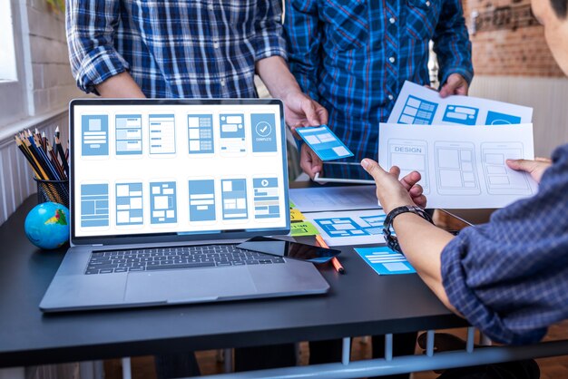 User experience teamwork mobile ux/ui designers working at co-working space workroom. Premium Photo