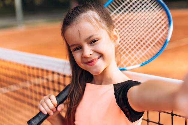 可愛い かわいい女の子がテニスコートでラケットとセルフィーを撮る プレミアム写真
