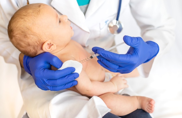 Vaccination baby, injection in the arm Premium Photo