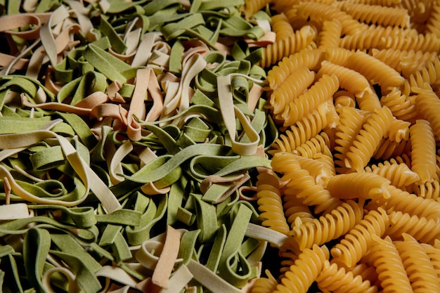 さまざまな種類と形の乾いたイタリアンパスタ イタリアのマカロニローフード背景やテクスチャ パスタ スパゲッティ スパイラルの形のパスタ プレミアム写真