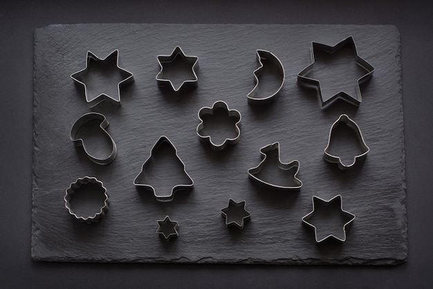 Premium Photo | Various christmas-themed cookie cutters on black.