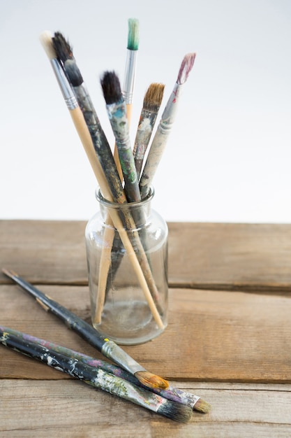 Premium Photo | Various paintbrush in glass jar against white background