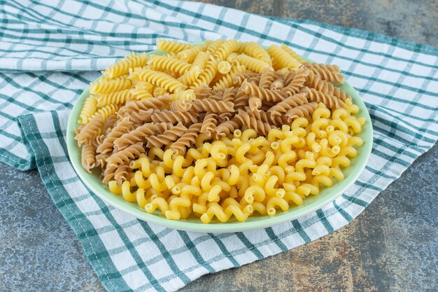 Free Photo | Various pastas in bowl on the towel, on the marble background.