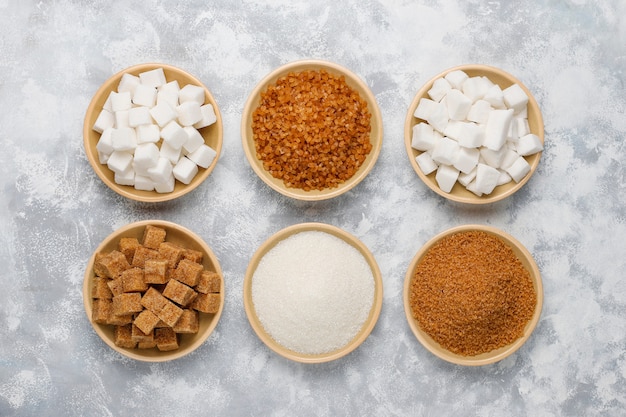 Various types of sugar, brown sugar and white on concrete ,top view Free Photo