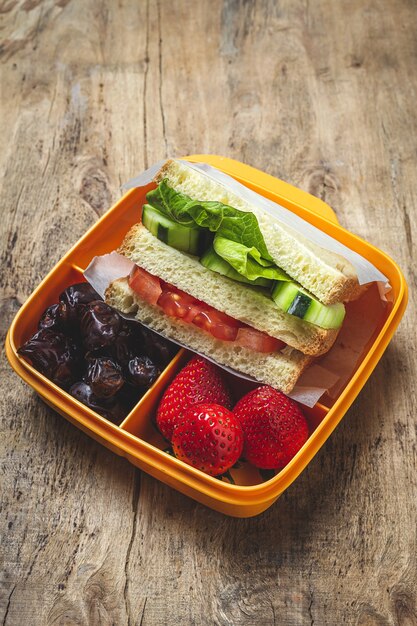 Premium Photo | Vegan sandwich in plastic container on wooden background