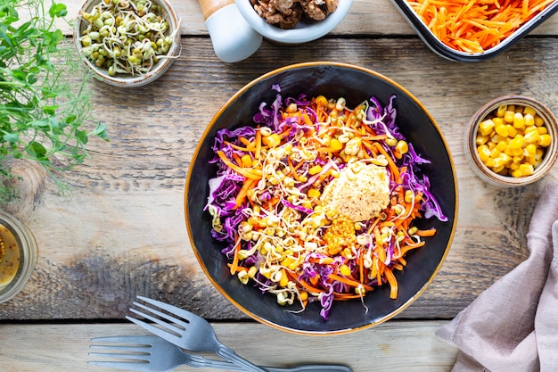 Vegetable Salad Of Fresh Red Cabbage With Carrots Onions Corn Mung Seedlings In A Plate On Wooden Background Selective Focus Top View Premium Photo