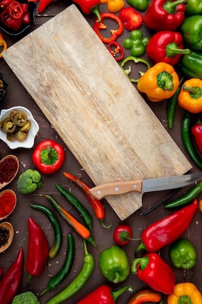 Vegetables with cutting board on maroon table | Free Photo