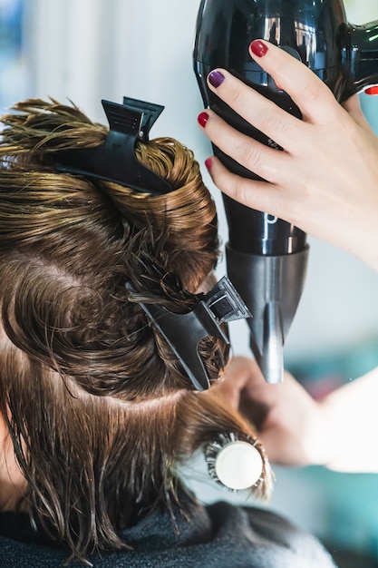 Free Photo | Vertical closeup shot of a hairdresser blow drying a woman ...