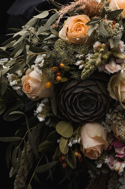 黒にオレンジと茶色のバラの豪華な花束の垂直クローズアップショット 無料の写真