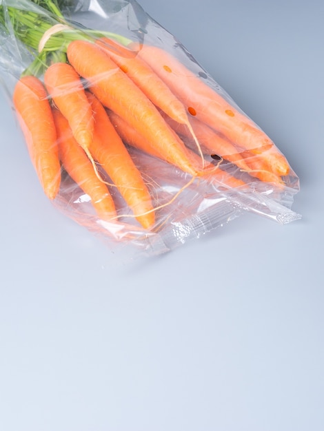 Download Premium Photo Vertical Image Of A Bunch Of Fresh Carrots Wrapped With A Plastic Bag