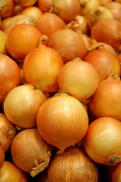 Premium Photo | Vertical image of a pile of onions selling at the market