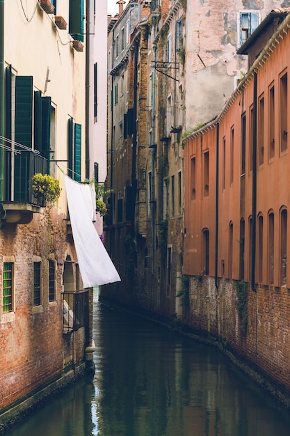 古いヨーロッパの建物の間の狭い水路の垂直方向のショット 壁紙に最適です 無料の写真