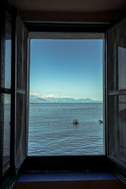 美しい海の景色を望む開いた窓の垂直ショット 無料の写真