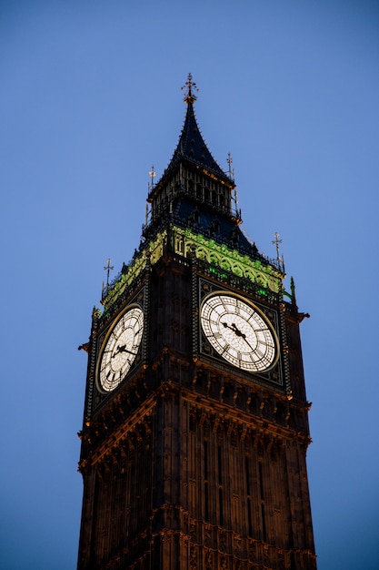 晴れた空の下でイギリスのロンドンのビッグベン時計塔の垂直ショット 無料の写真
