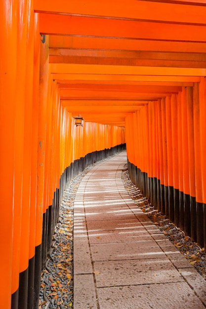 京都の伏見稲荷神社へのオレンジ色の入り口の垂直ショット 無料の写真