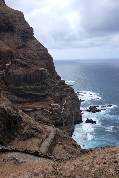 free-photo-vertical-shot-of-a-rock-at-the-seashore-under-the-gloomy-sky