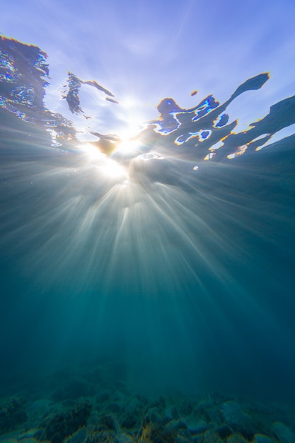 Free Photo | Vertical shot of sun rays sliding through the ocean ...
