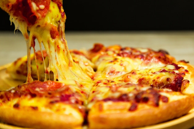 premium-photo-very-cheesy-pizza-slice-in-hand-hot-pizza-slice-with