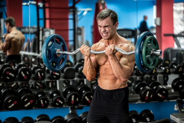 Premium Photo | Very power athletic guy standing workout in the gym