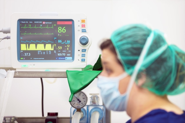 Veterinarian doctor portrait in operating room. anesthesia monitoring in the background Premium Photo