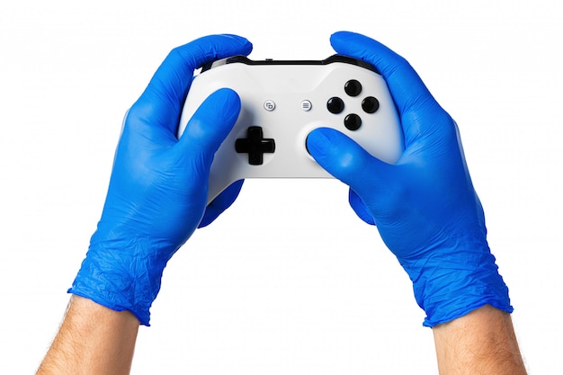 ゲーマーの手袋をはめた手でビデオゲームコンソールコントローラー 自宅での隔離中のゲーム コロナウイルス プレミアム写真