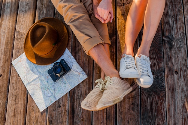 View from above legs of couple traveling in summer dressed in sneakers Free Photo